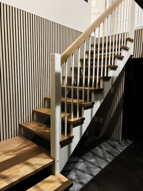L-shaped staircase with oak steps and light finish.