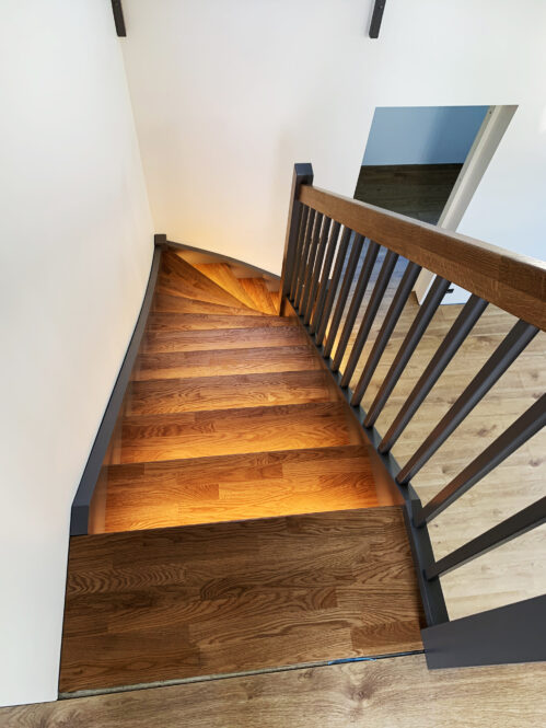 L-shaped wooden staircase with oak steps and LED lighting.